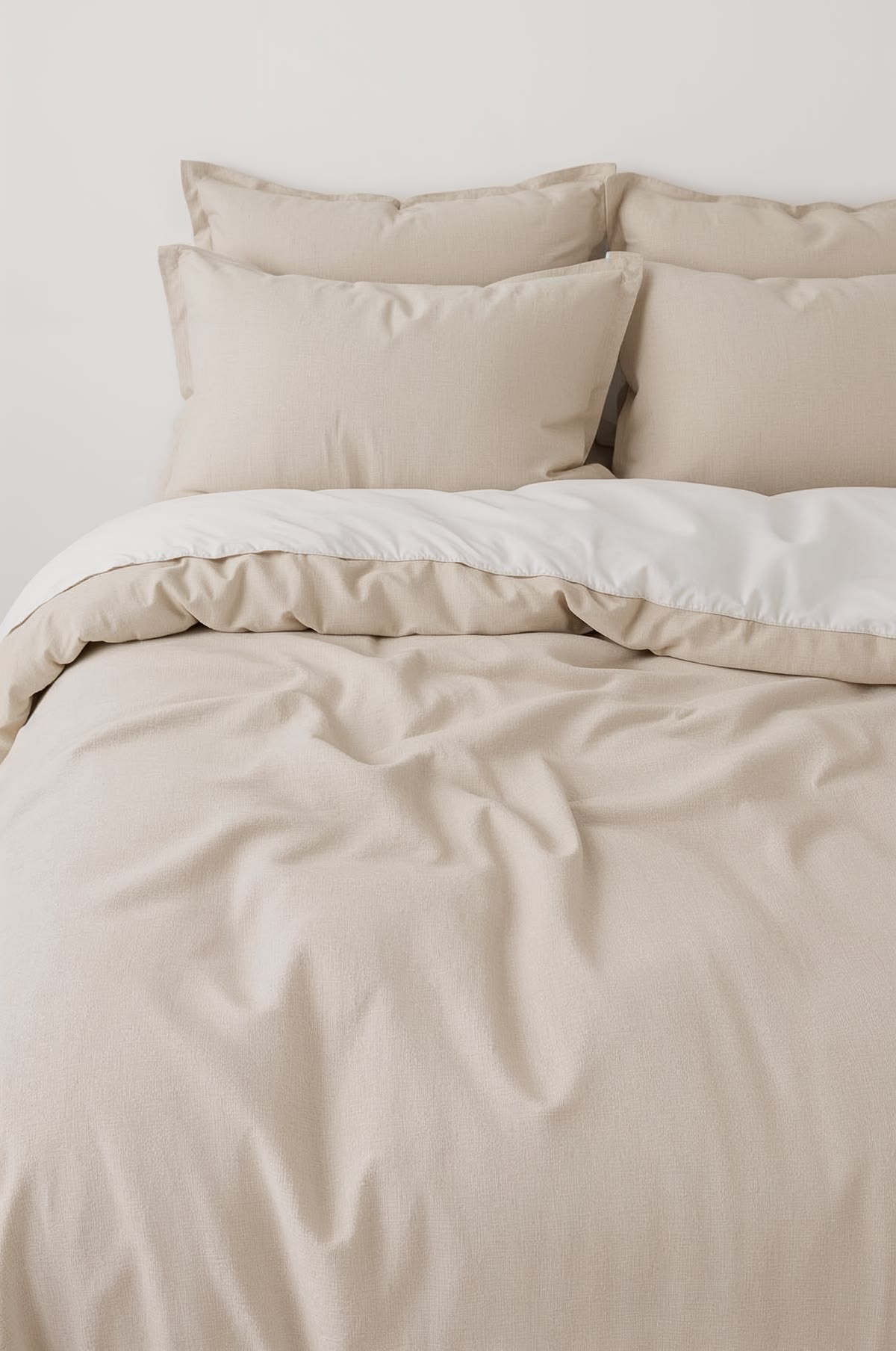 Neatly made bed with neutral linen bedding and pillows